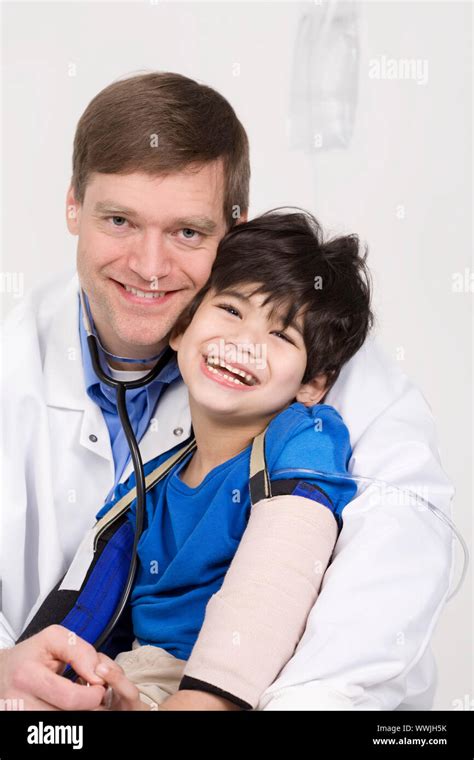 Male Doctor In Early Forties Holding Five Year Old Disabled Patient