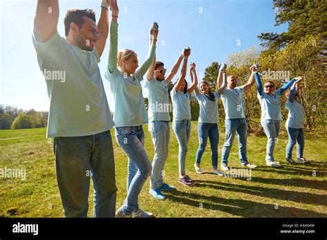 Group Of Happy Volunteers Holding Hands Outdoors Stock Photo Alamy