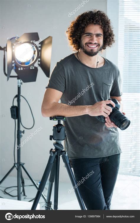 Happy Photographer Standing In Studio Stock Photo By ©wavebreakmedia