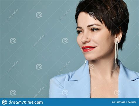Portrait Of Friendly Smiling Short Haired Brunette Woman In Blue Official Jacket And Earrings