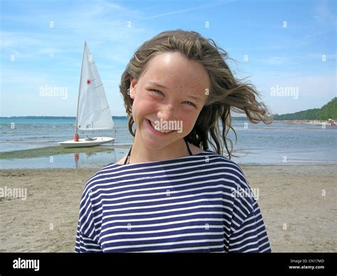 Portrait Of Young Girl On Beach With Sailboat In Background Sandbanks