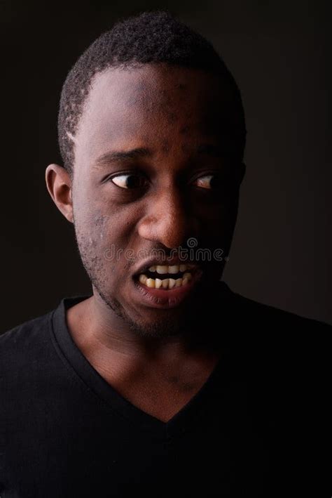 Studio Shot Of Angry Young Black African Man Screaming In Dark R Stock