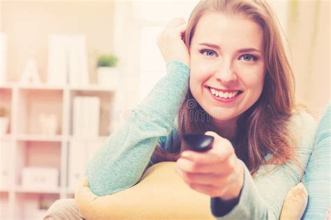 Young Woman Smiling While Watching Tv In Her House Stock Image Image