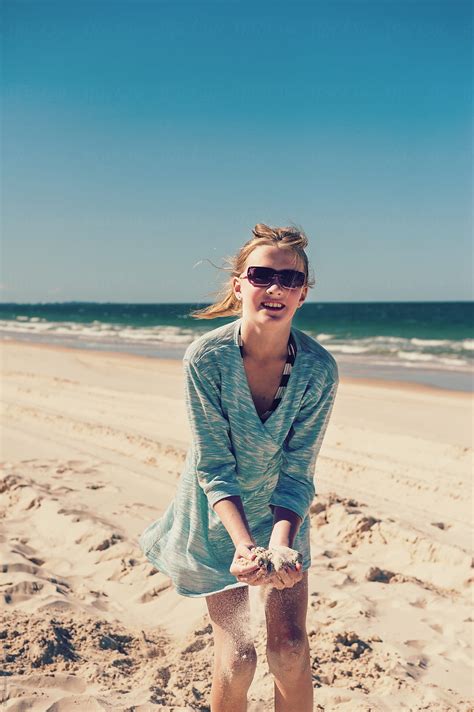 Tween Girl Playing In The Sand At The Beach Wearing Sunglasses By Stocksy Contributor