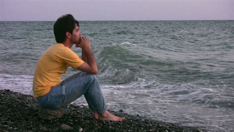 Young Man Sitting Alone On The Bench On The Beach Stock Footage Video