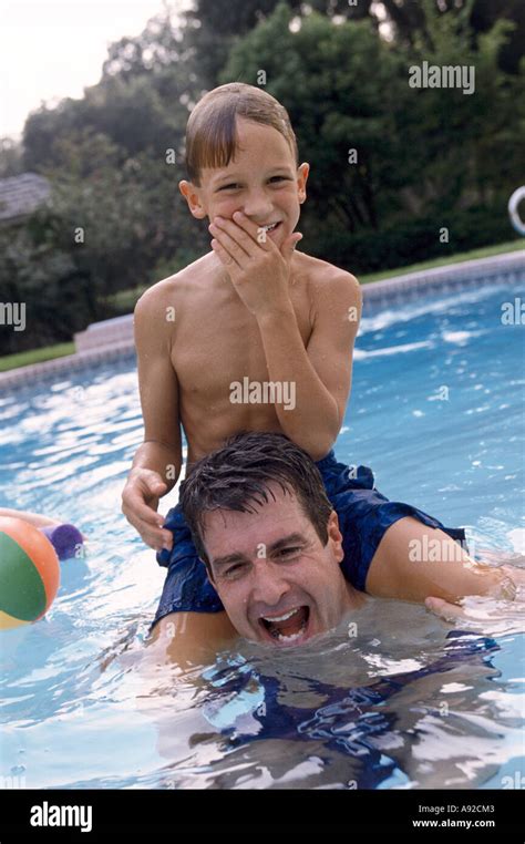 Father Carrying His Son In A Swimming Pool Stock Photo Alamy