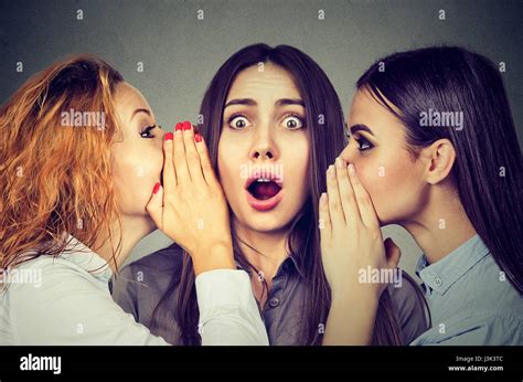Three Young Women Telling Whispering A Secret Gossip Each Other In The