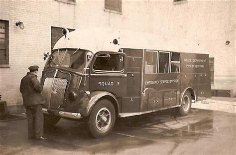An Old Fire Truck Parked In Front Of A Building With A Man Standing