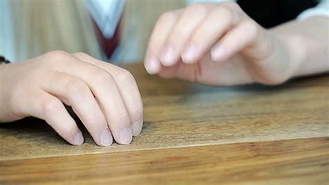 Girl Tapping With Her Fingernails On Wooden Table Because Of Irritation