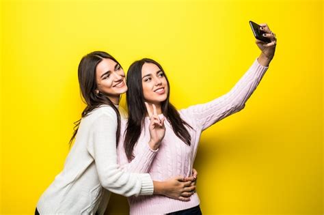 Portrait De Deux Jolies Filles V Tues De Chandails Debout Et Prenant Un