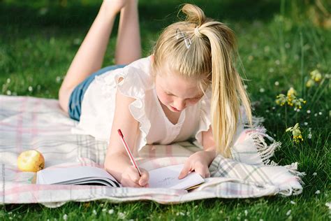 Tween Girl Drawing Outdoors In Early Summer By Stocksy Contributor