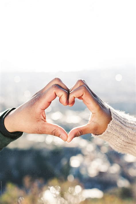 Couple With Heart Shaped Hands Above City Del Colaborador De Stocksy