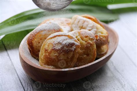 Poffertjes In Oval Wooden Bowl Being Dusted With Powdered Sugar 1265313