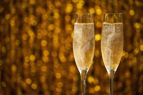 Premium Photo Two Glasses Of Champagne On Golden Bokeh Background