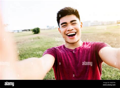 Happy Asian Young Man Taking A Selfie Portrait With Mobile Phone In