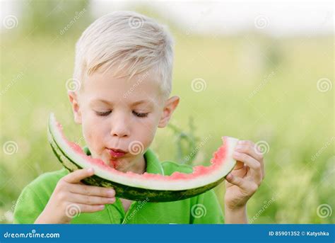 Funny Little Toddler Boy With Blond Hairs Eating Watermelon Outdoors