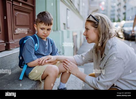 Madre Consolando A Su Hijo Pequeño En Su Primer Día De Escuela Sentado En La Escalera Y