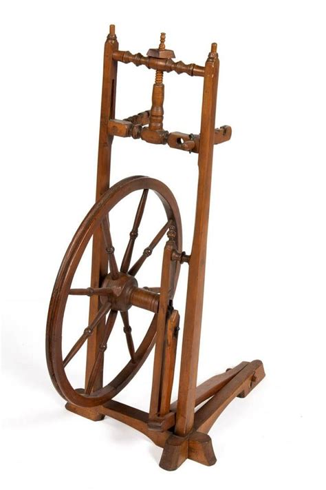 A Wooden Spinning Wheel On A Stand With Two Spokes Attached To The