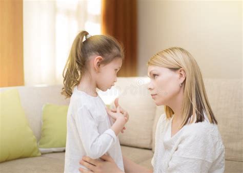 Beautiful Mother Is Comforting Her Sad Little Daughter At Home Stock