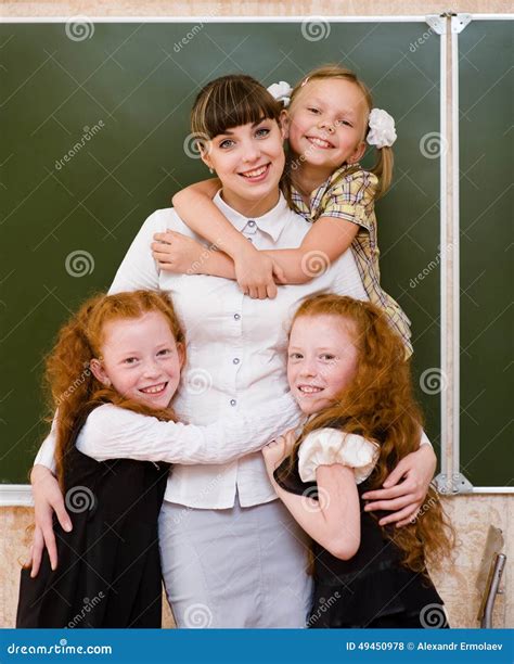 Children Hugging Their Teacher Stock Photo Image Of Desk Indoor