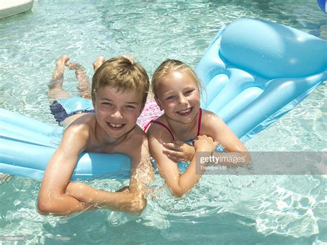Young Boy And Girl On A Airbed In A Swimming Pool High Res Stock Photo