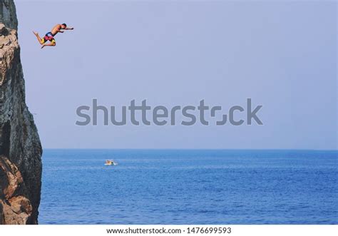 Young Man Jumping Off Cliff Into Stock Photo Edit Now 1476699593