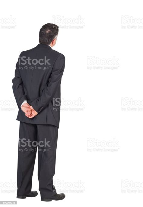 Mature Businessman Standing With Hands Behind Back Stock Photo