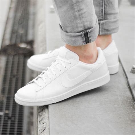 Plain White Nike Lace Up Sneakers Worn By A Person Dressed In Pale