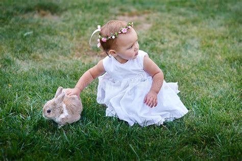 Little Girl Playing With A Rabbit On The Grass Stock Photo Image Of