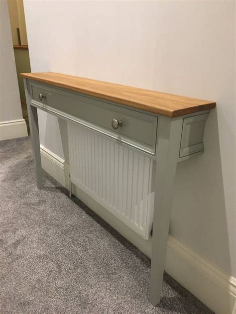 A Grey Painted Console Table Against A White Wall