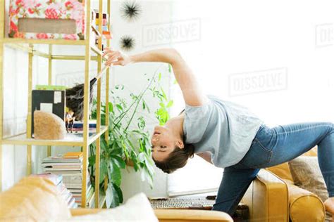 Woman Bending Over Backwards While Dusting Stock Photo Dissolve