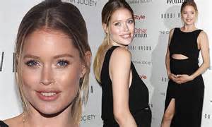 pregnant doutzen kroes cradles her blossoming belly in midriff baring black gown while