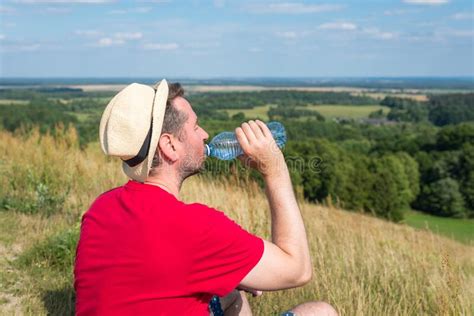 Traveler Drinks Water In The Mountainshiker With Backpack Relaxing On