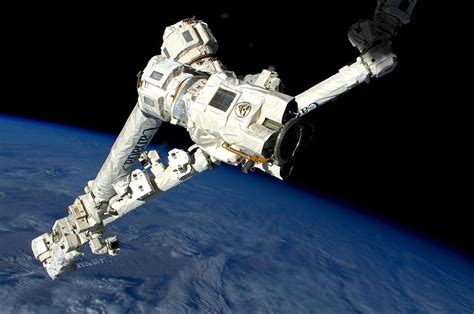Astronauts Give A Hand To Robotic Arm On Spacewalk Outside Station