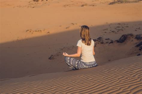 Premium Photo Young Woman Meditating In Rad Sandy Desert At Sunset Or