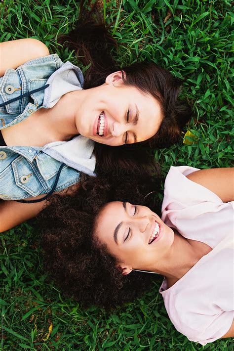 Two Laughing Girls Laying On The Grass Del Colaborador De Stocksy Ellie Baygulov Stocksy