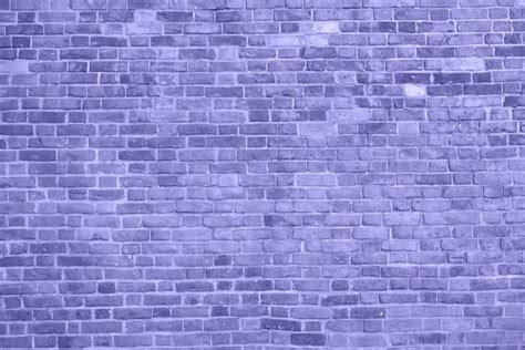 금이 가고 질감이 있는 보라색 벽 벽돌 벽 배경 2022 개념의 색상을 닫습니다 프리미엄 사진