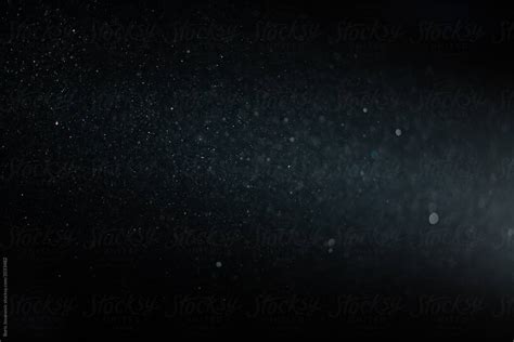 Close Up Of Dust Particles Flying In Front Of A Light Beam By Stocksy