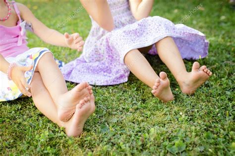Cute Bare Legs Of Little Girls On Meadow Stock Photo By ©locrifa 79917012