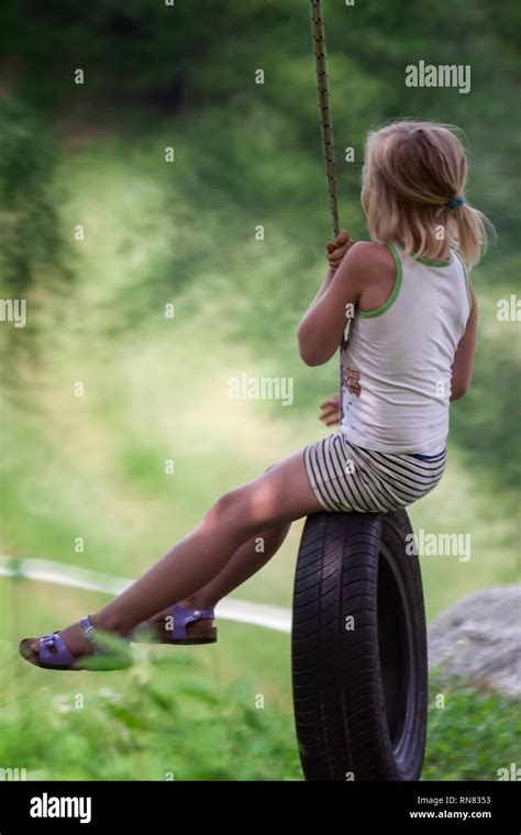 Cute Young Blond Girl On Tire Swing Stock Photo Alamy