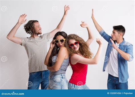 Portrait Of Joyful Young Friends With Sunglasses Dancing In A Studio