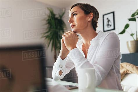 Woman Sitting At Her Desk In Office Thinking Deeply Business Woman