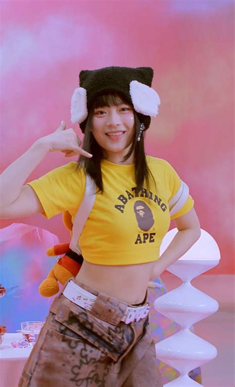A Woman Wearing A Yellow Shirt And Hat Posing For The Camera With Her Hand On Her Hip