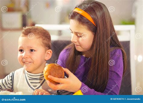 Boy And Girl Preparing And Eating Healthy Meal At Home Stock Photo