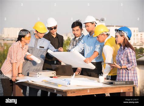 Group Of Engineers And Architects Discuss At A Construction Site