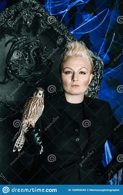 Photo Of A Female Witch Queen Holding Bird And Sitting On A Gothic