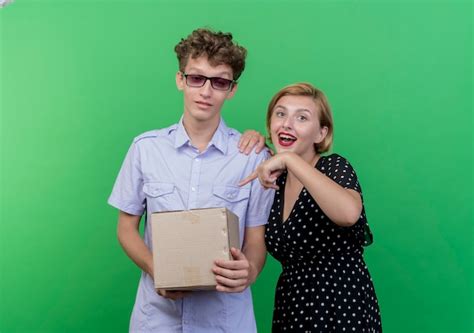 Free Photo Young Beautiful Couple Confused Man Holding Box Package While His Girlfriend