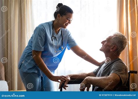 Female Doctor Interacting With Senior Man In Nursing Home Stock Image