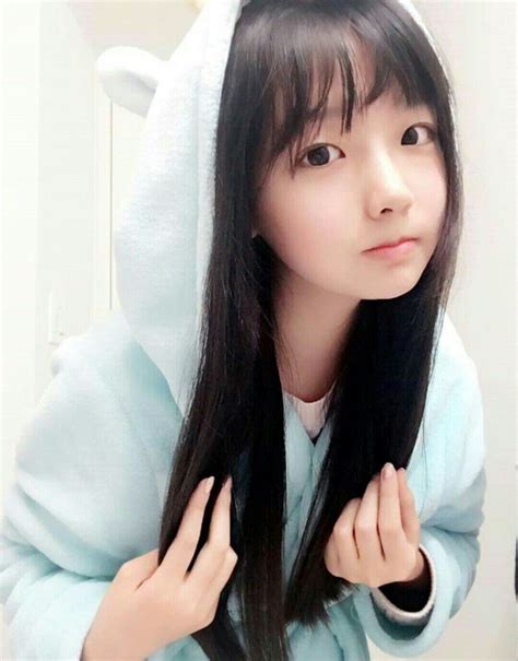 A Woman With Long Black Hair Wearing A Blue Unicorn Hoodie And Looking