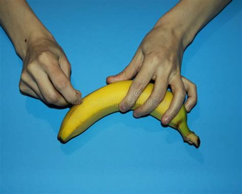 female hands holding a tropical exotic fruit banana and a needle without removing the peel